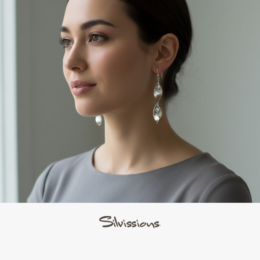 Woman wearing silver earrings with a neutral background, featuring the brand 'Silvissions'.