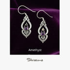 Pair of silver earrings with amethyst stones on a beige card, branded 'Silvissions'.
