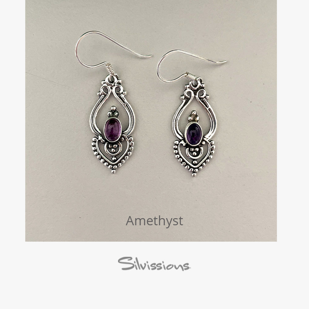 Pair of silver earrings with amethyst stones on a beige card, branded 'Silvissions'.