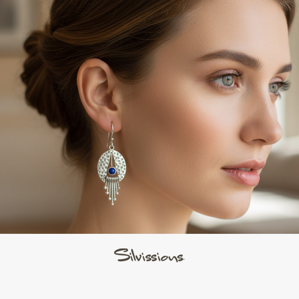 Woman wearing silver jewelry with lapis lazuli stones on a gray background, featuring the brand 'Silvassions'.