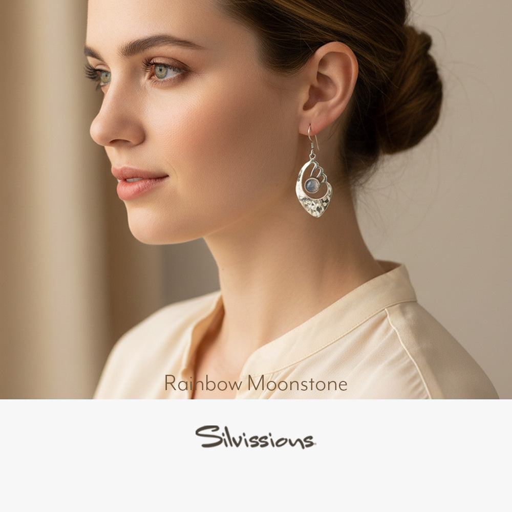 Woman wearing a silver earring with a visible brand name on a neutral background
