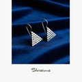 Triangle-shaped earrings on a blue fabric background with 'Silvissions' branding.