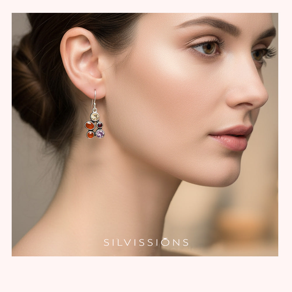Close-up of a woman wearing colorful earrings with 'Silviossions' branding.