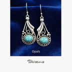 Pair of silver earrings with blue stones on a beige card, featuring the brand 'Silvissions'.