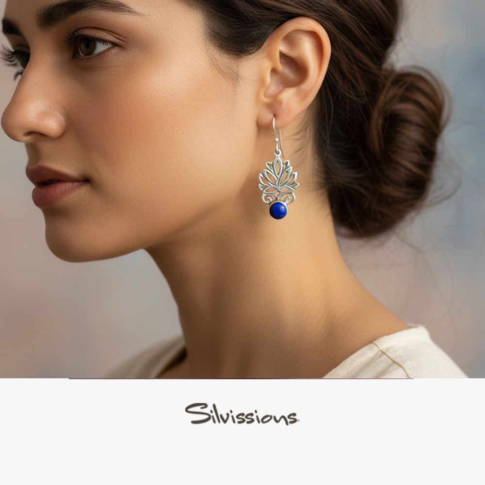 Close-up of a woman wearing a silver earring with a blue gemstone, branded 'Silvissions'.