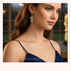 Close-up of a woman wearing a silver earring with a blue dress, branded 'Silviossions'.