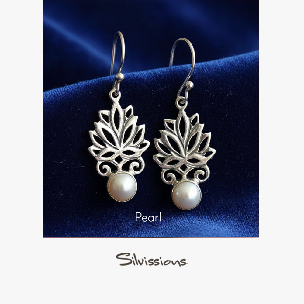 Silver lotus flower earrings with pearls on a blue satin background, branded 'Silvissions'.