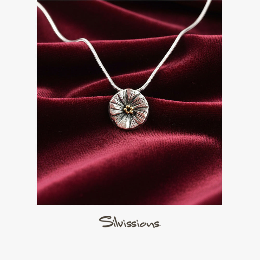 Silver necklace with a round pendant on a red satin background, featuring the brand 'Silvissions'.