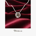 Silver necklace with a round pendant on a red satin background, featuring the brand 'Silvissions'.
