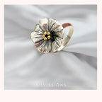 Silver ring with gold accents on a white fabric background, featuring the brand 'Silvissions'.