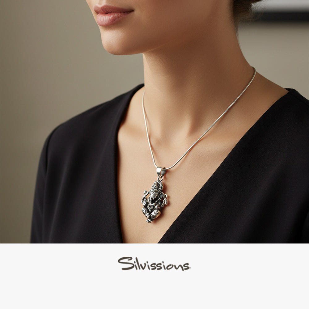 Silver necklace with a pendant worn by a person, brand 'Silvissions' visible