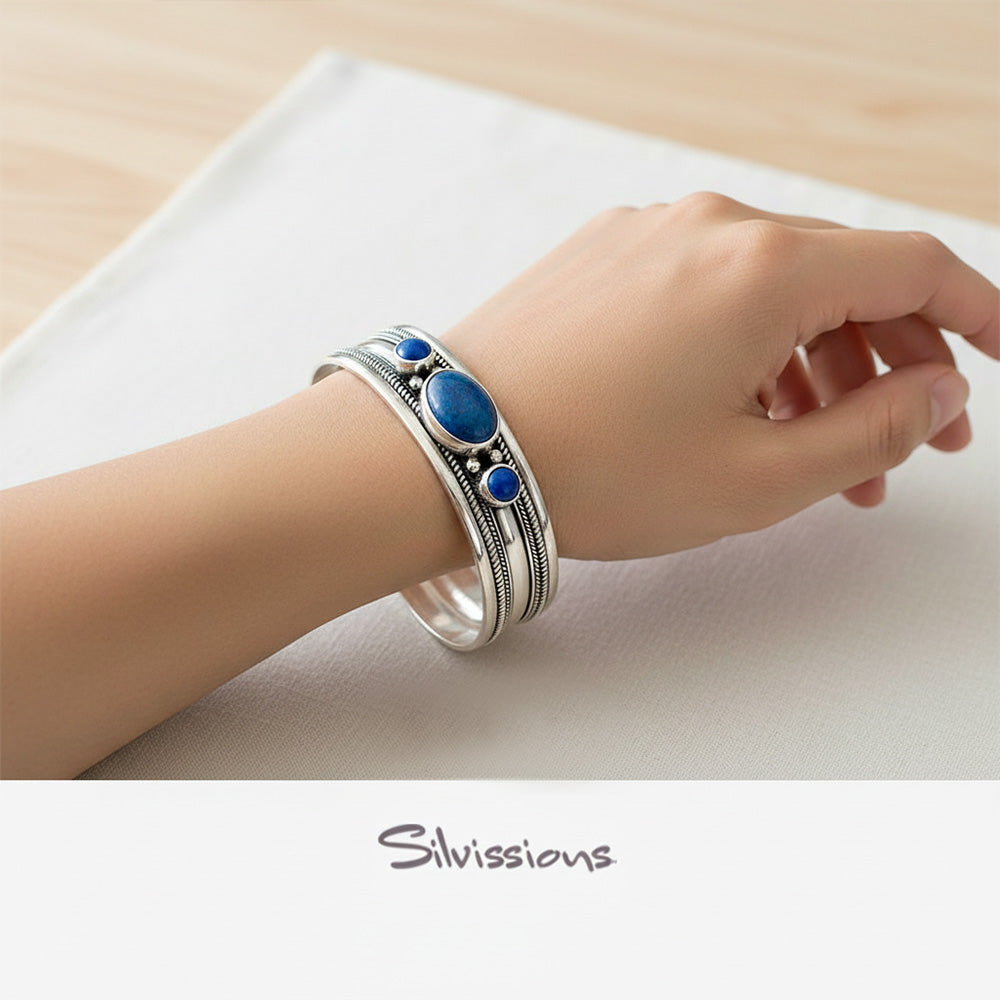 Silver bracelet with blue stones on a wrist, brand 'Silvissions' visible