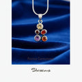 Silver necklace with gemstone pendant on a soft background, featuring the brand 'Silvissions'.