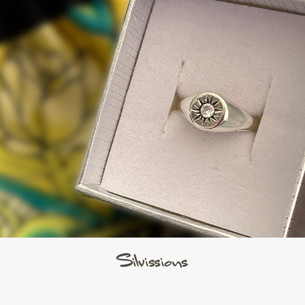Silver ring with a zircon gemstone in a box, branded 'Silvissions'.