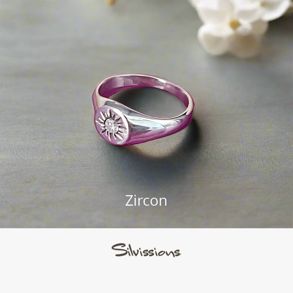 Zircon gemstone ring with silver band on a gray surface, featuring Silvissions Jewelry branding.