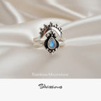 Silver ring with an oval-shaped rainbow moonstone on a soft background