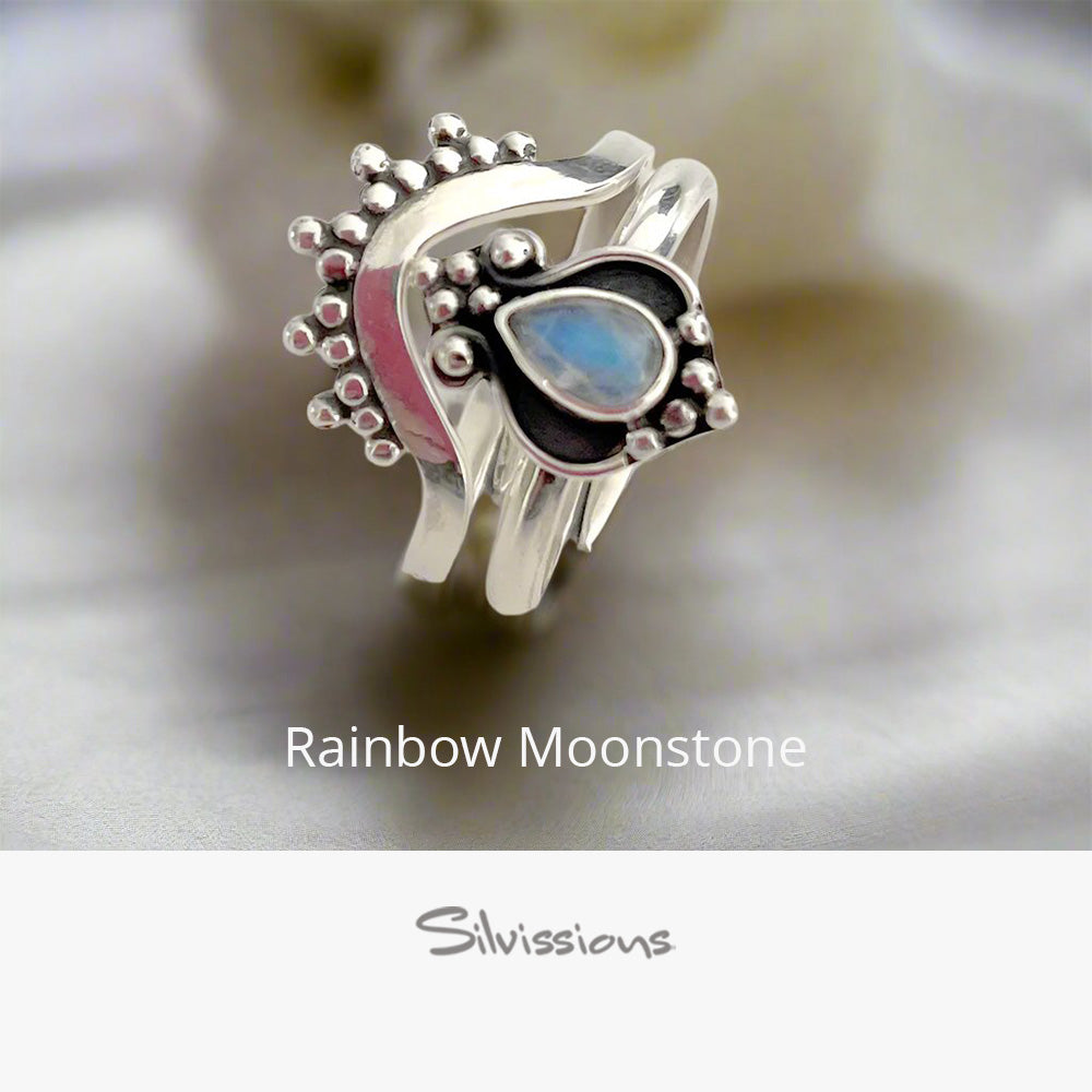 Silver ring with a heart-shaped rainbow moonstone on a soft background