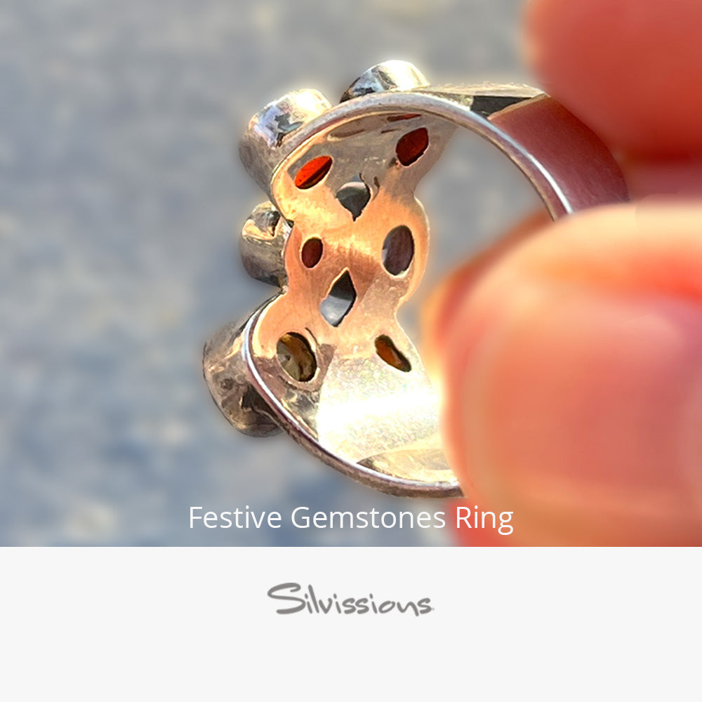 Festive gemstones ring held by a hand with 'Silvissions' branding.