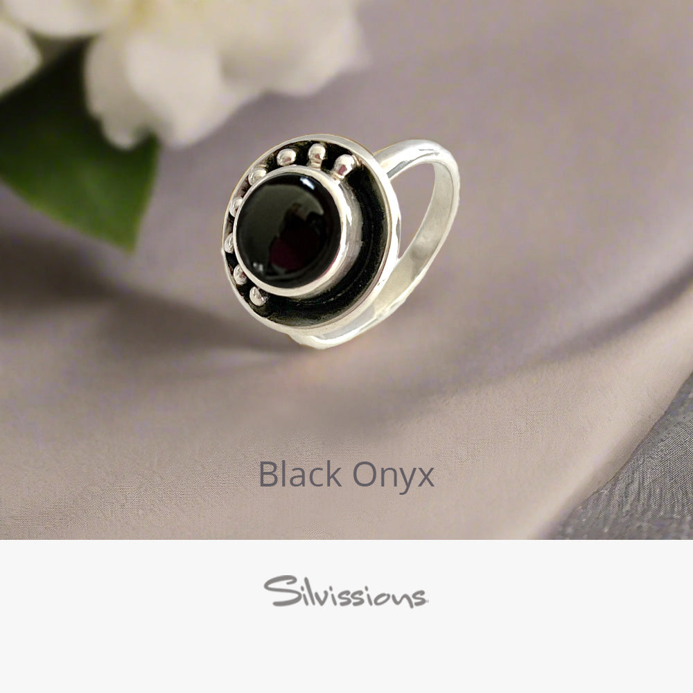 Silver ring with black onyx stone on a neutral background, featuring the brand 'Silvissions'.