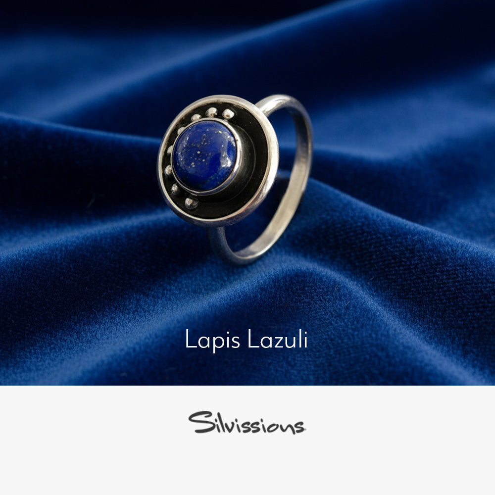 Silver ring with lapis lazuli stone on blue fabric, featuring the brand 'Silvissions'.