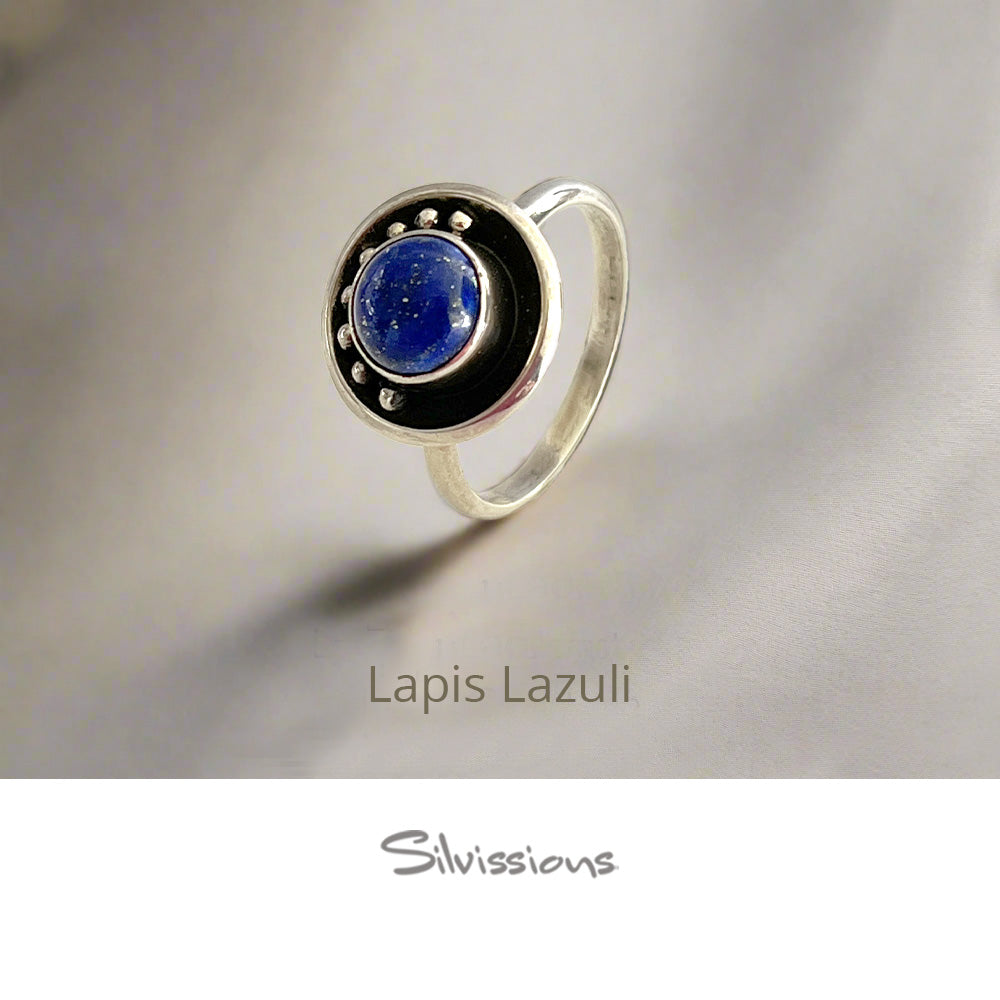 Silver ring with a blue gemstone on a gray background, branded 'Silvissions'.