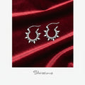 Silver hoop earrings on red satin fabric with 'Silvissions' branding.