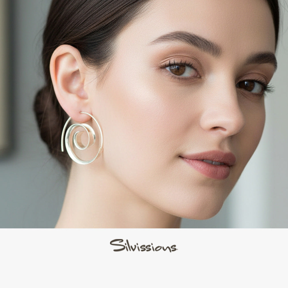 Woman wearing silver hoop earrings with a neutral background