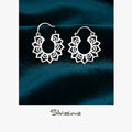 Silver hoop earrings on a dark blue fabric background with 'Silvissions' branding.
