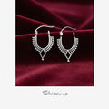 Silver hoop earrings on a burgundy fabric background with 'Silvissions' branding.