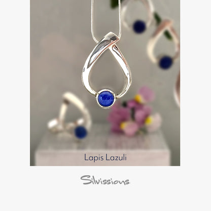 Silver pendant with a blue gemstone on a light gray background, branded 'Silvissions'.