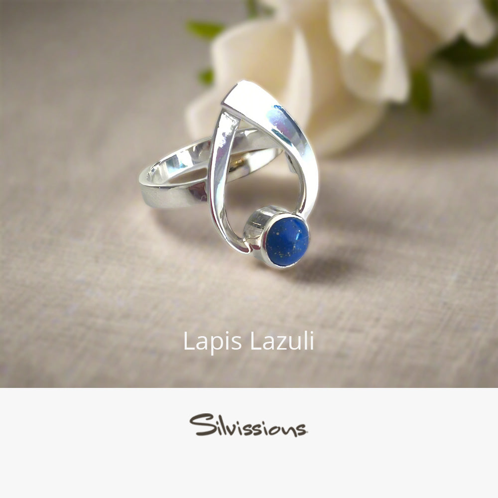 Silver ring with a blue stone on a beige background, branded 'Silvissions'.