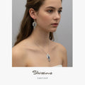 Teen Girl wearing silver jewelry with lapis lazuli stones on a gray background, featuring the brand 'Silvassions'.