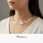 A person showcasing a sterling silver cuff necklace with gold accents, with the brand name 'Silvissions' visible.