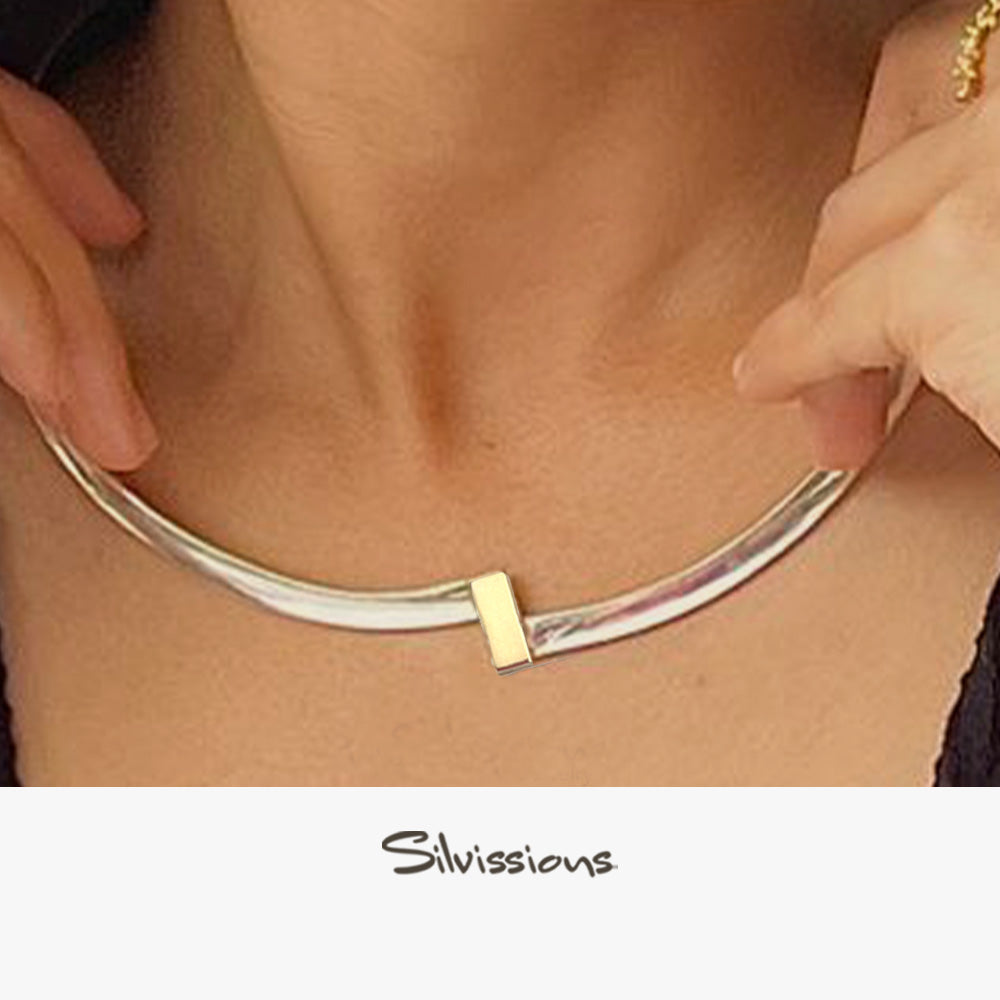 A person showcasing a sterling silver cuff necklace with gold accents, with the brand name 'Silvissions' visible.