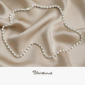 Silver necklace on beige fabric with 'Silvissions' branding