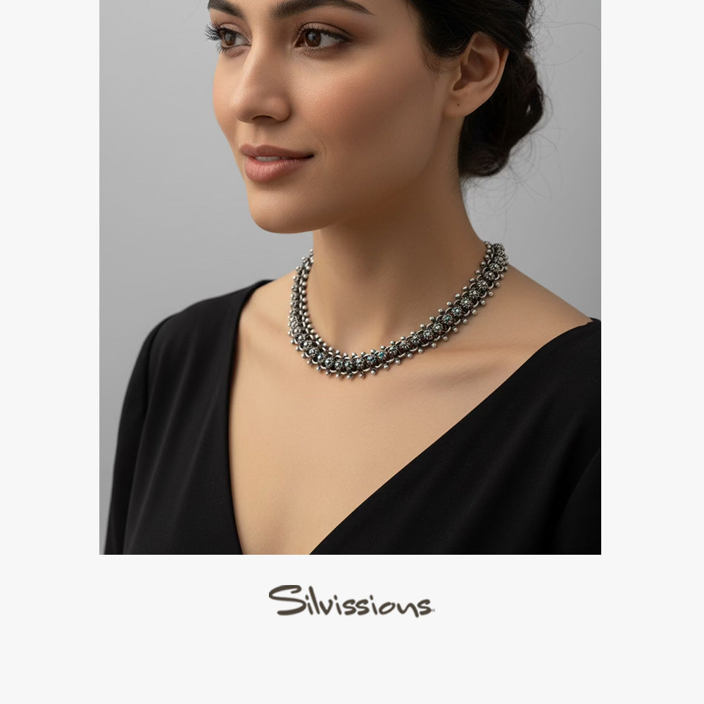 Woman wearing a necklace with a neutral background, featuring the brand 'Silvissions'.
