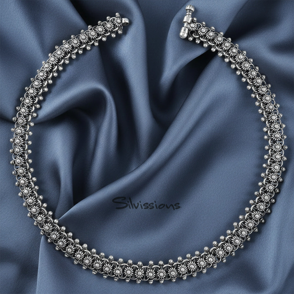 Silver necklace on a blue satin background with 'Silvissians' branding.