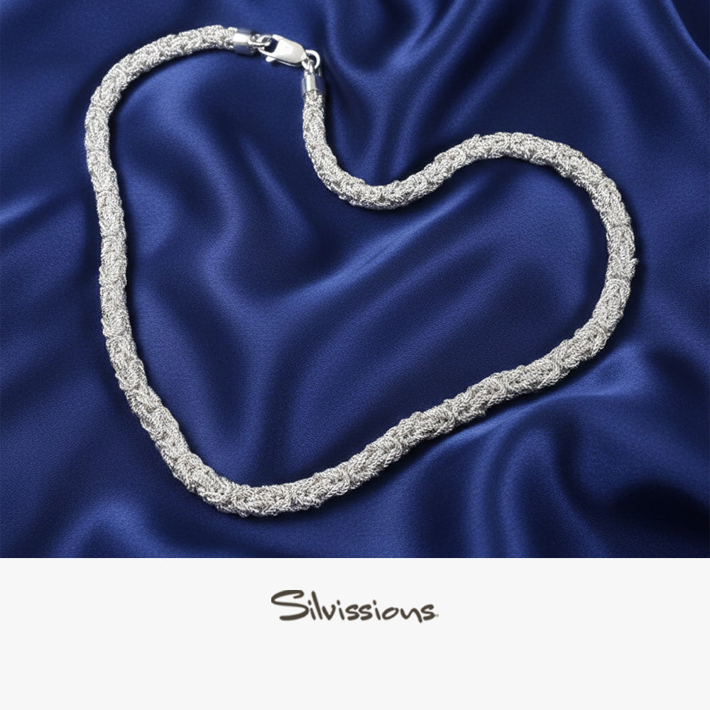 Silver necklace on a blue satin background