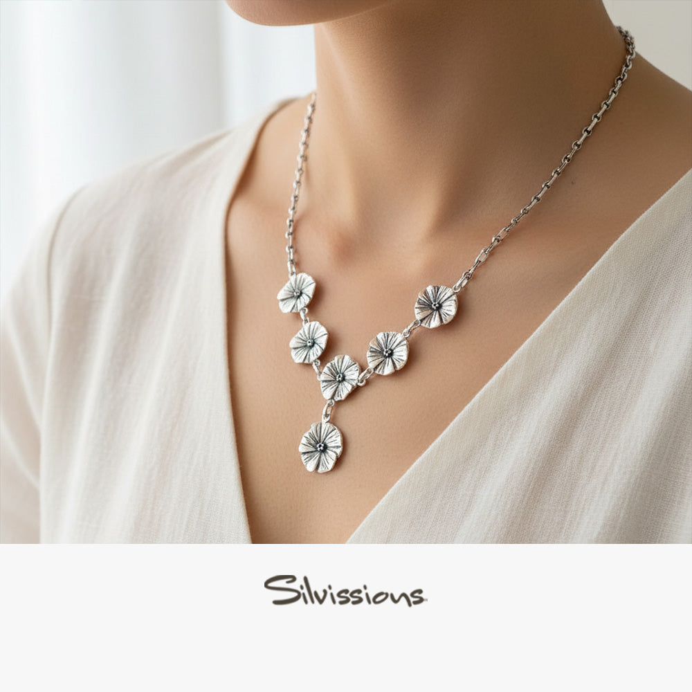 Silver floral necklace on a mannequin with 'Silvassions' branding.