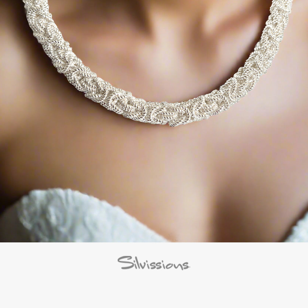 Silver necklace worn by a person with a blurred background, featuring the brand 'Silvissions'.