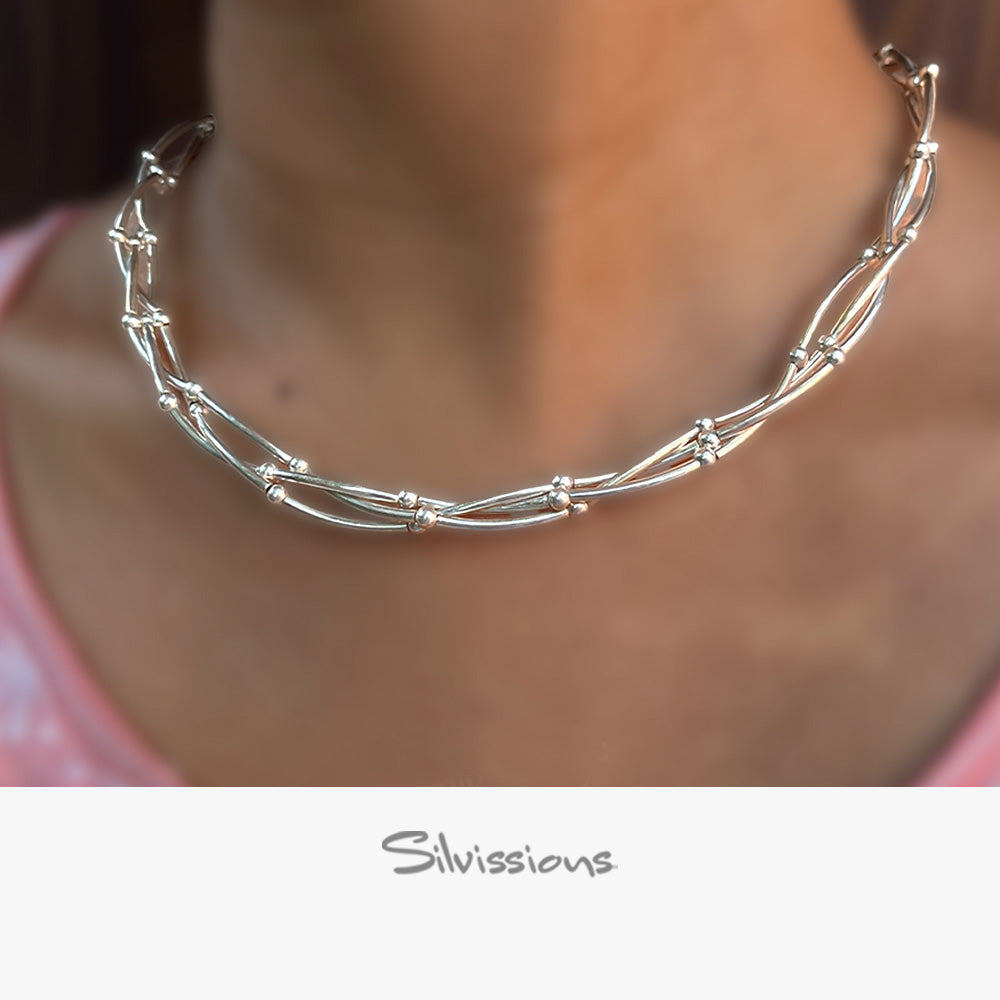 Silver necklace on a blurred background with 'Silvissions' branding.