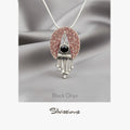 Jewelry pendant with black onyx gemstone and silver accents on a gray fabric background, branded 'Silvissions'.