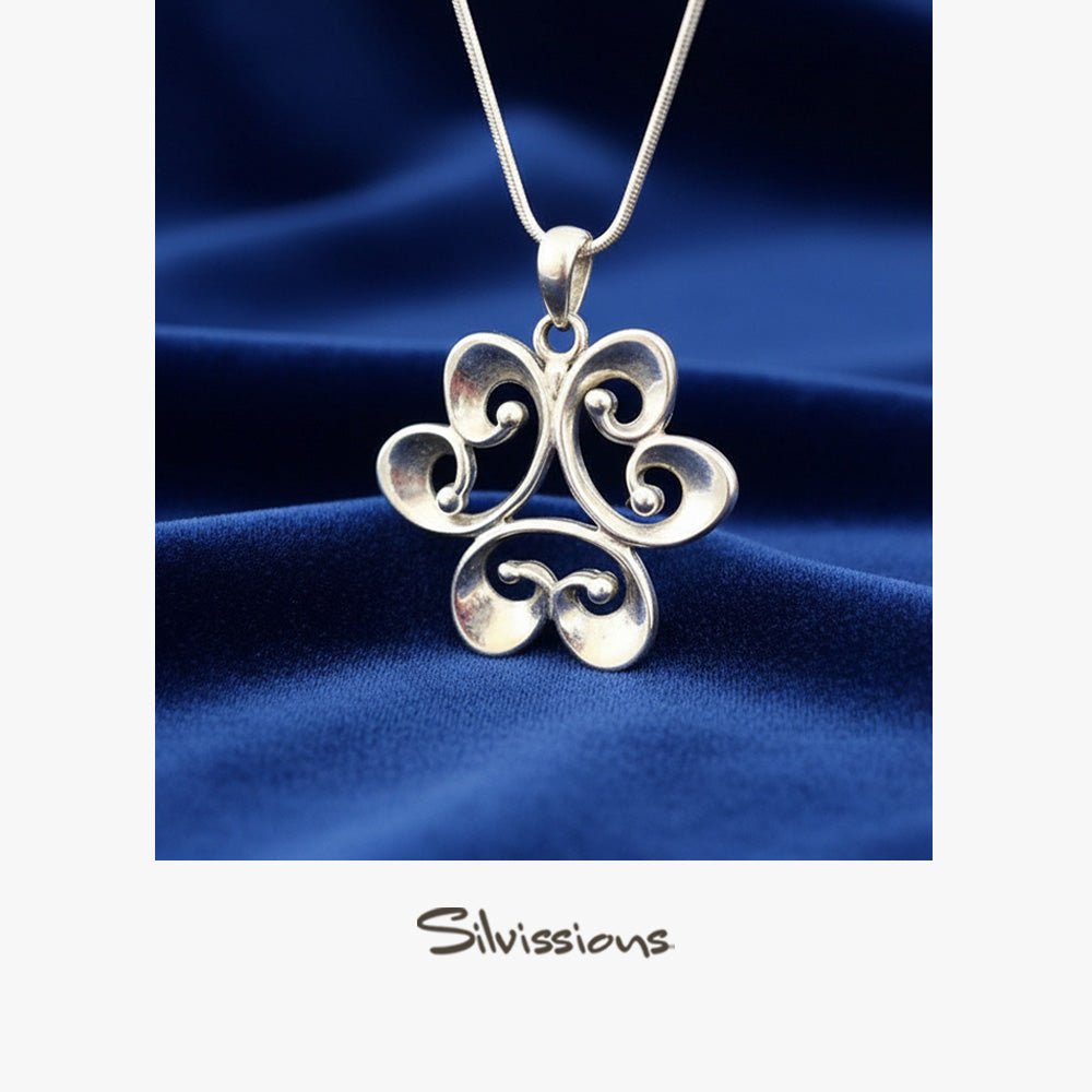Silver pendant on a blue fabric background with 'Silvissions' branding.