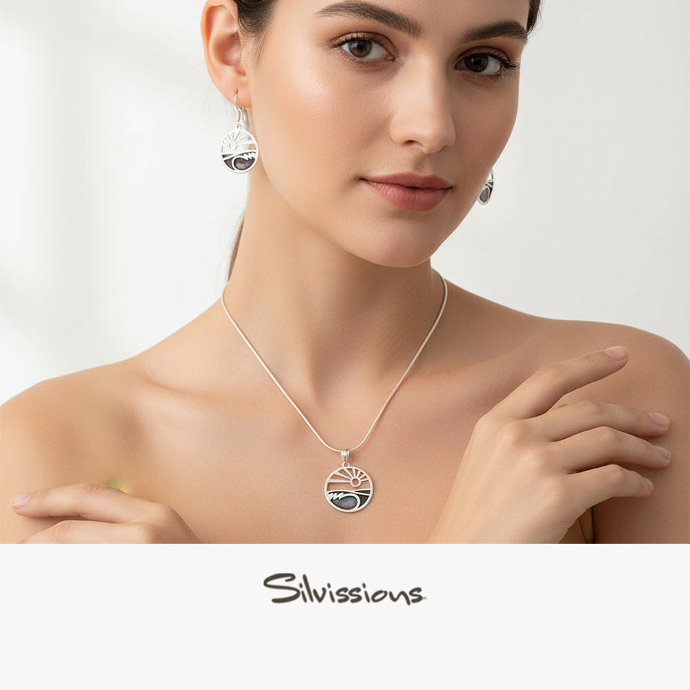 Woman wearing a silver necklace and earrings with 'Silvissions' branding.