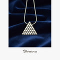 Triangular pendant necklace with metallic beads on a dark blue fabric background, branded 'Silvissions'.