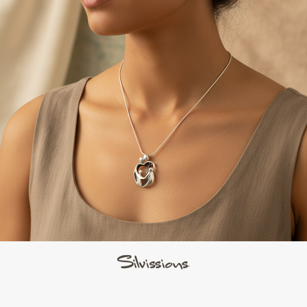Silver necklace with a pendant on a model wearing a beige top, branded 'Silvassions'.