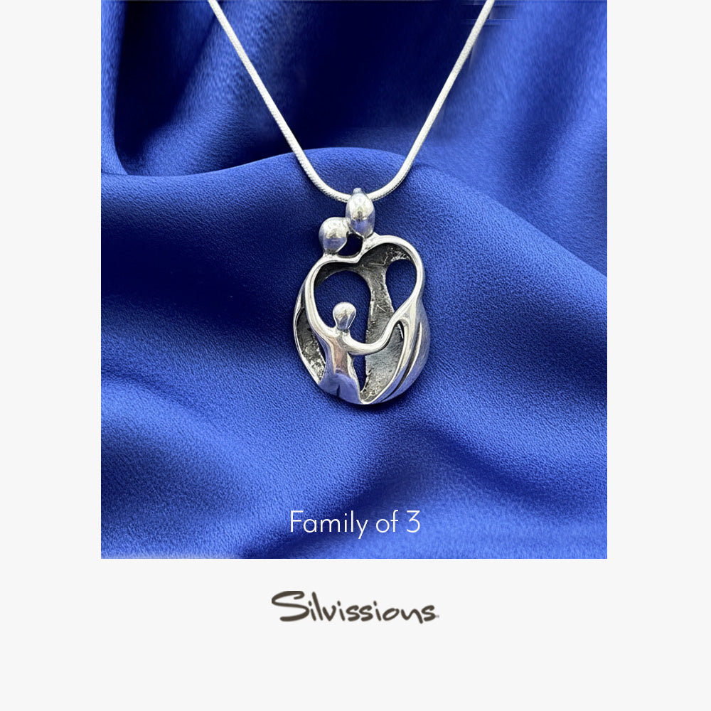 Silver pendant on a blue fabric background with 'Silvissions Jewelry' branding.