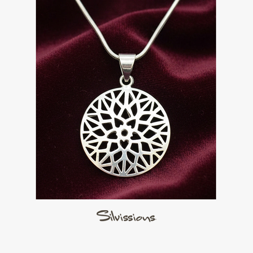 Silver necklace with a intricate pendant on a burgundy satin background, featuring the brand 'Silvissions'.