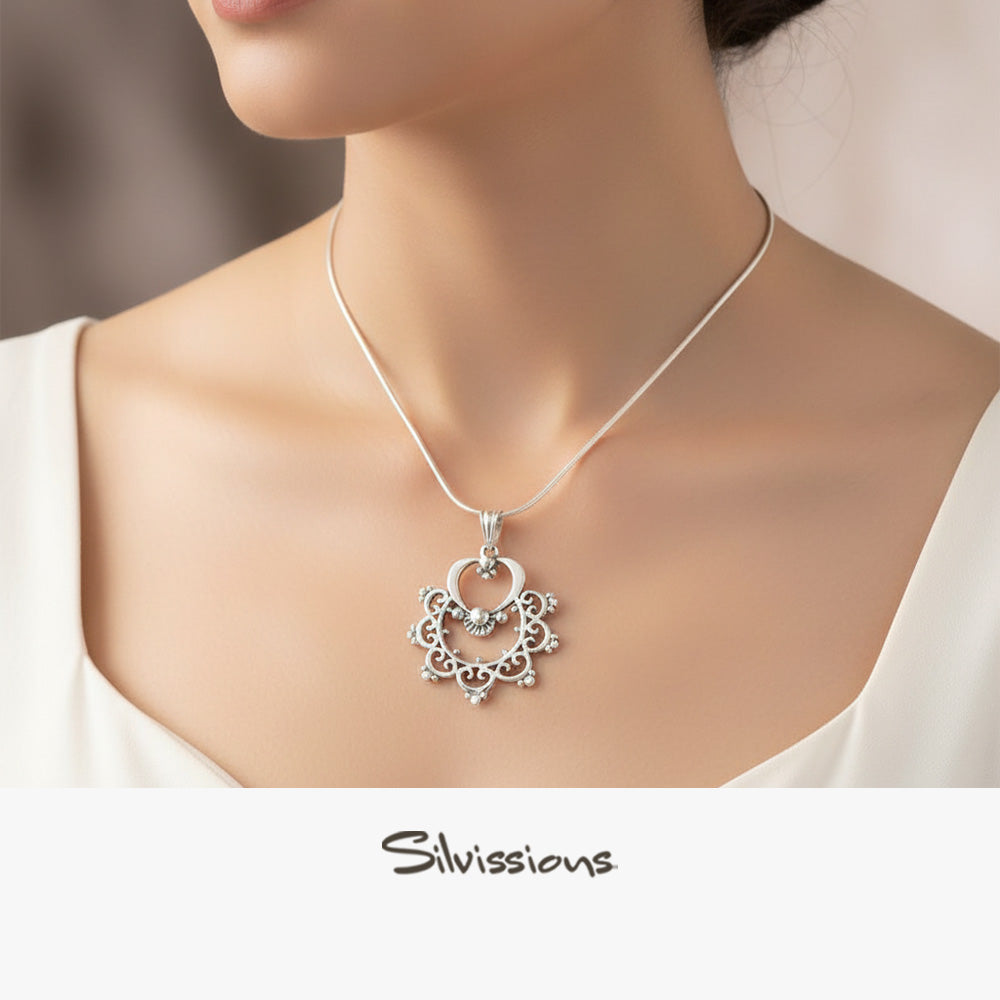 Silver necklace with a decorative pendant on a model, featuring the brand 'Silvassions'.