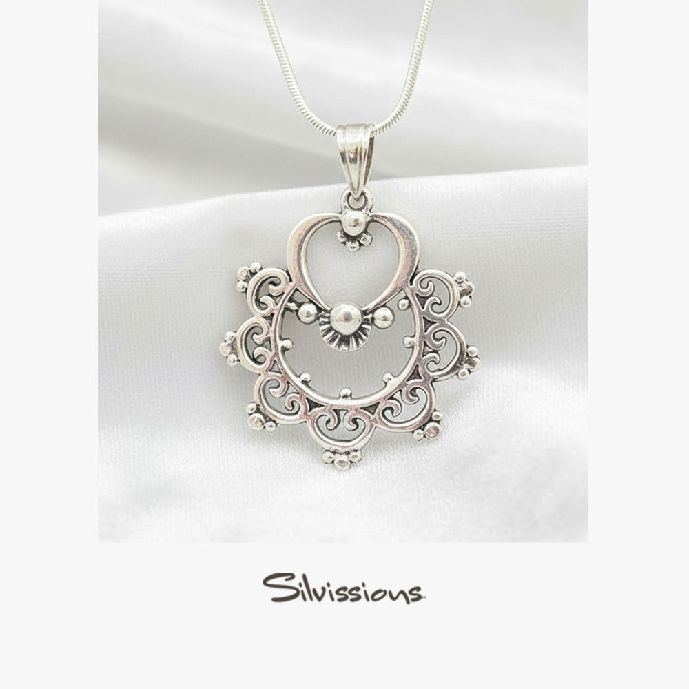 A sterling silver necklace with a handcrafted delicately detailed pendant, displayed against a natural background with the brand name 'Silvissions' visible.